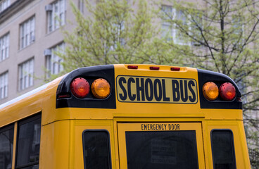 School bus parked in front of school in Brooklyn New York City. Yellow back to school ride.