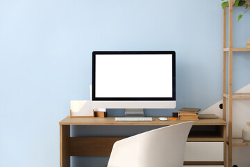 Workplace with modern computer near blue wall in room