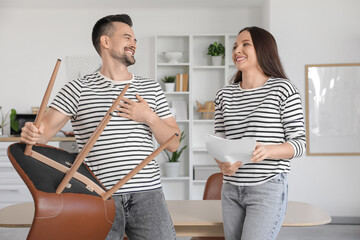 Happy couple with manual assembling chair in kitchen