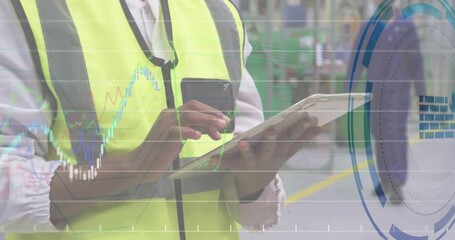 Facility operator monitoring warehouse data using tablet, smartphone, overlaying finance charts - Powered by Adobe