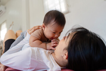 Mother and baby having fun together on a yoga mat at home.