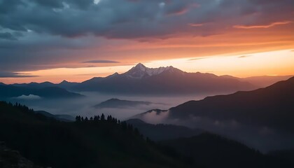 Obraz premium Majestic mountain peak illuminated by the warm hues of sunrise in the clouds