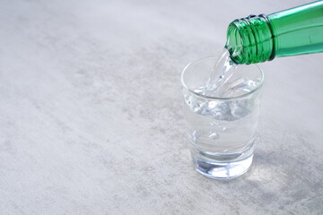 韓国の伝統的な蒸留酒、焼酎（ソジュ）をグラスに注ぐ
