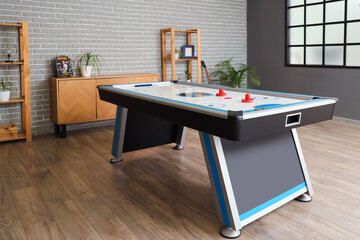 Interior of room with air hockey, chest of drawers and shelf units