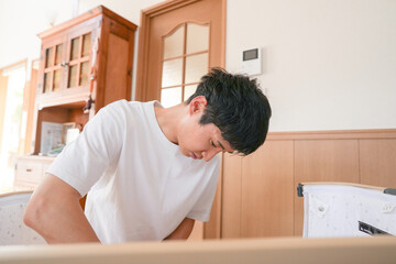 A Japanese couple in their 20s is gently preparing a baby bed for their newborn. Their quiet teamwork creates a warm space filled with love and care. Perfect for parenting or family-themed content.