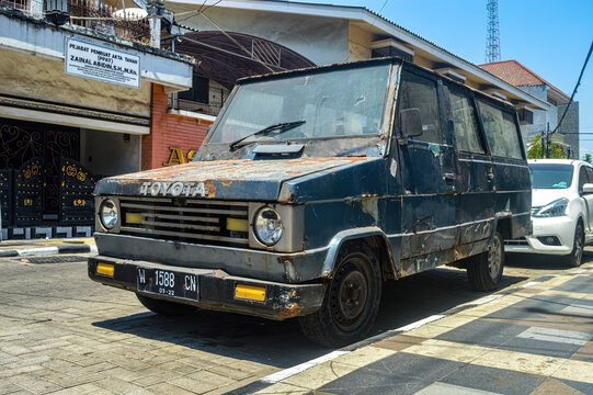 an ancient and dull Toyota Kijang car parked on the side of the old city road, Indonesia, 17 September 2023.