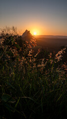 Sunset glow over wild grass and volcanic peaks in Queensland, Australia