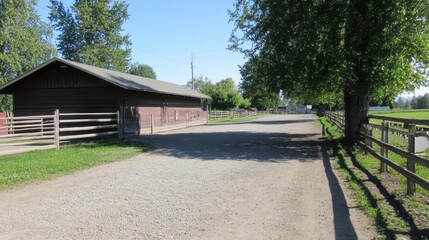 Serene rural landscape featuring a gravel road leading to a rustic barn surrounded by trees