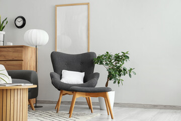 Interior of living room with black armchair, ottoman and lamp
