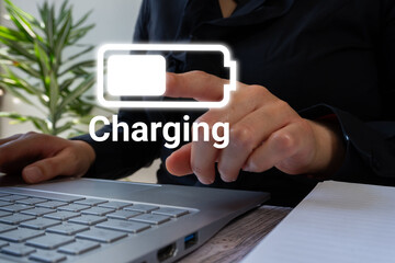 A woman working on a computer pointing at a document with a charging battery icon