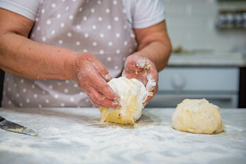 Granny baking buns in the kitchen. High quality photo