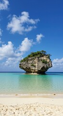 Fototapeta premium Solitary rocky island in a calm turquoise sea with a sandy tropical beach