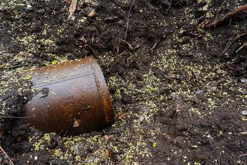 A rusty, dirty bucket has been left abandoned on the ground, which highlights the serious pollution...