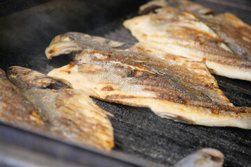 Grilling fresh fish on an outdoor barbecue during summer gathering