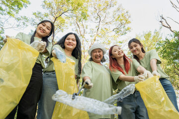Volunteers participating in park cleanup activity, Group of cheerful volunteer women picks up trash...