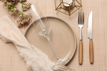 Beautiful table setting with gypsophila flowers and burning candle on napkin