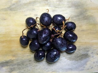 Close up of purple grapes on wooden background