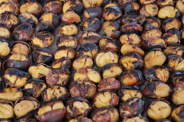 Roasted chestnuts displayed at outdoor market during cool autumn day