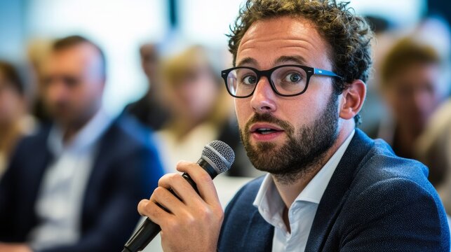 Confident business speaker presenting at professional conference holding microphone, corporate meeting or seminar with engaged audience, leadership and public speaking concept.