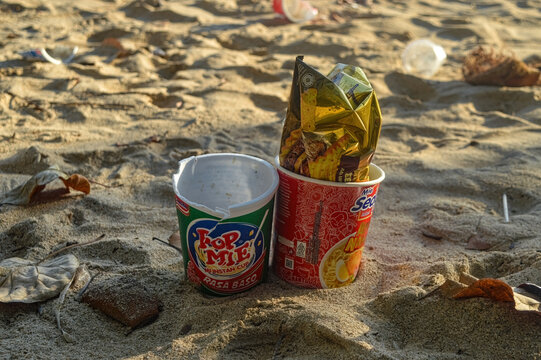 instant noodle cup packaging littering the beach sand, Indonesia, 2 October 2023.