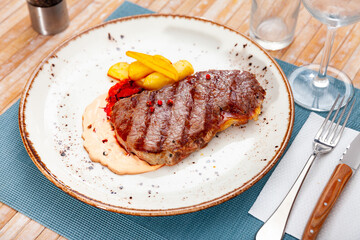 Tasty homemade grilled beef tenderloin steak and fried potato wedges served with sauce