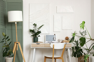 Interior of room with comfortable workplace near white wall