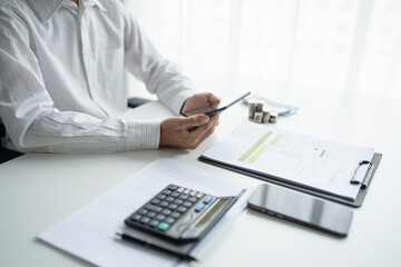 Fototapeta premium Business man&nbsp;holding digital tablet using Stock market application and reviews finances and manages budget with money cash