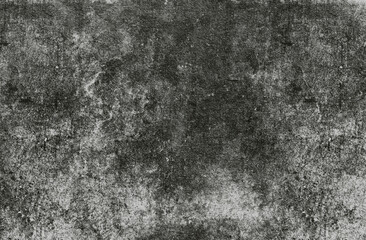 A grungy, textured surface of dark grey and black, featuring visible scratches, scuffs, and stains...