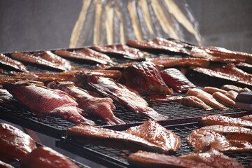 An assortment of smoked fish on a grill rack offers a delectable culinary experience.