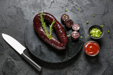 Composition with tasty blood sausage on dark background, top view