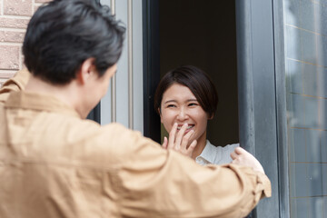 家に訪問した業者と笑顔で話す女性