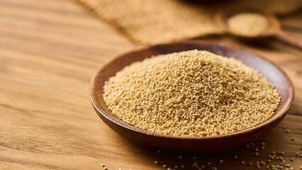closeup pile of amaranth seed grain whole in wood bowl on wooden table homemade rustic style food...