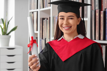 Female graduate with diploma in library, closeup