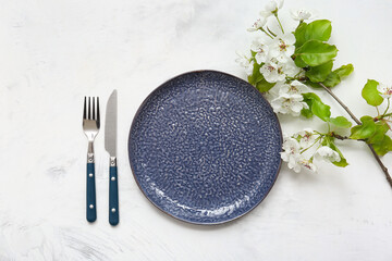 Beautiful table setting with blooming branch on white background