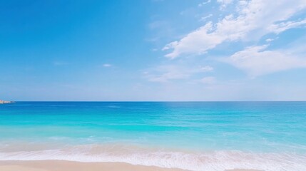 Obraz premium Serene Beach Landscape with Bright Blue Sky and Calm Ocean Waves