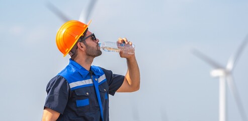 engineer Man in a blue and orange shirt is drinking water