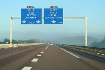 motorway signs in France above a misty freeway - panneaux autoroutiers en France au dessus d'une...