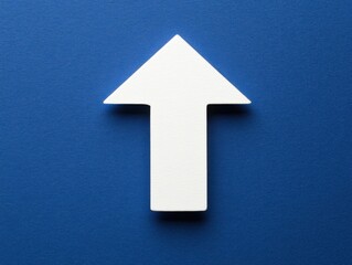 Fototapeta premium Upward Directional Arrow Pointing Straight Ahead on Blue Background Overhead Flat Lay Symbolizing Growth and Progress
