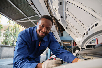 EV car check, Black male mechanic worker inspects and maintains service of electric engine and...