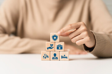 Health insurance concept. Hand arranging cubes wooden block with healthcare medical icon. Access to...