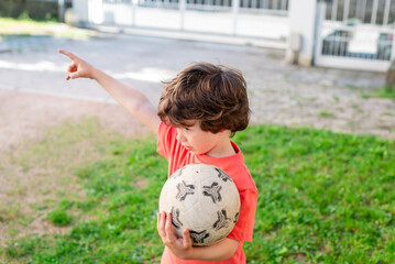 Young boy plays soccer and gestures during outdoor activity