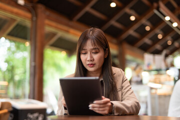 young woman in cafe using tablet computer