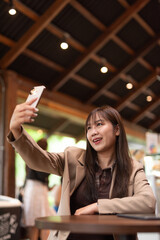 young woman in a cafe taking selfie