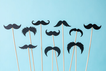 row of black mustaches on a blue background