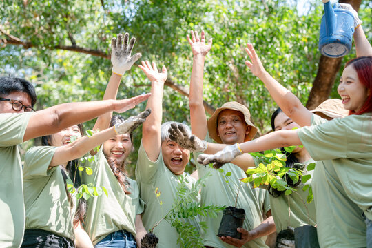 Happy Volunteers Team Celebrating Outdoors, Group of Happy Asian Volunteers Team in Park for Charity Event with Joining Hands