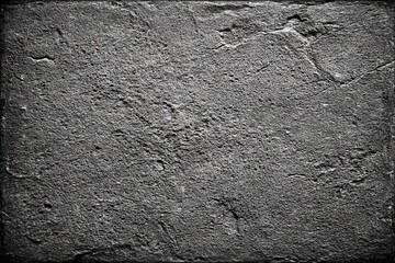 Rough textured stone surface with natural patterns and a monochrome appearance, ideal for backgrounds or design elements.