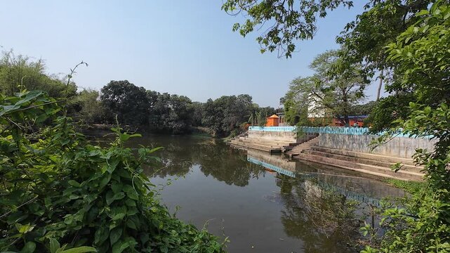 Tranquil Pond Reflecting Sacred Gauri Shankar Temple  Amid Trees with Calming Atmosphere and Natural Serenity, Mahinathpur, Madhubani, Bihar 