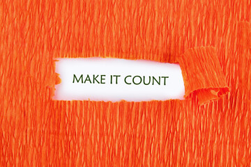 MAKE IT COUNT words written under the orange paper on a white background
