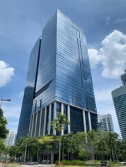 Obraz premium Modern glass skyscraper viewed from below with palm trees in Jakarta Indonesia on a sunny day architectural photography