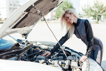 Female car mechanic repairing car engine